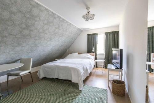 um quarto com uma cama, uma mesa e uma televisão em Hello Zeeland - Villa Jhr de Casembrootplein 23 em Domburg