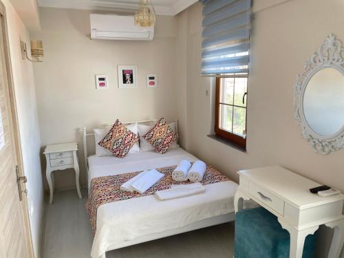 a small bedroom with a bed and a mirror at Ada Olympos Otel in Bozcaada