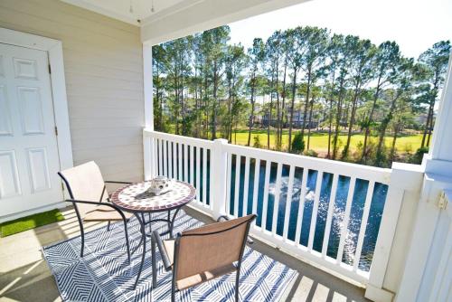 a balcony with a table and chairs on a porch at Massive Waterfront Pool Lakefront Condo Famous Barefoot Resort in North Myrtle Beach