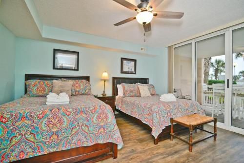 a bedroom with two beds and a ceiling fan at Waterfront Luxury Huge Condo with 15000sf Pool in Myrtle Beach