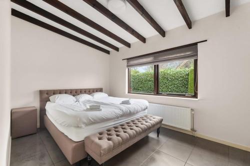 een slaapkamer met een groot bed en een raam bij Hello Zeeland - Villa Park Reygersbergh 11 in Oostkapelle