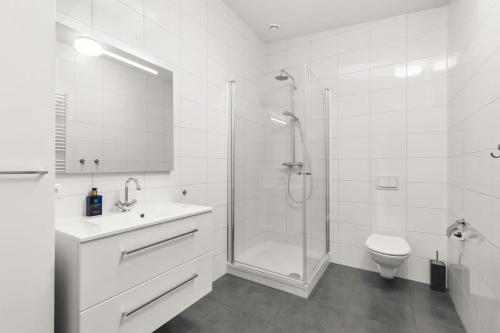 een badkamer met een douche, een wastafel en een toilet bij Hello Zeeland - Villa Park Reygersbergh 11 in Oostkapelle