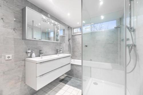een badkamer met een wastafel en een glazen douche bij Hello Zeeland - Appartement Loverendale 38 in Domburg