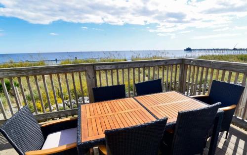 a wooden table and chairs on a balcony with the beach at Hazels Castle Huge 2 in 1 Oceanfront House near Pier in Myrtle Beach