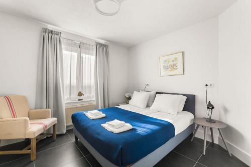ein Schlafzimmer mit einem großen Bett und einem Stuhl in der Unterkunft Hello Zeeland - Appartement Domburgseweg 11-2 in Domburg