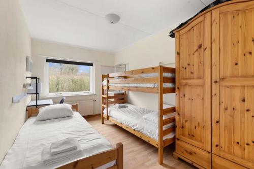 1 Schlafzimmer mit 2 Etagenbetten und einem Fenster in der Unterkunft Hello Zeeland - Vakantiehuis Oosterpark 92 in Oostkapelle