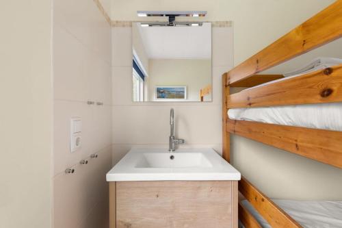 ein Bad mit einem Waschbecken und einem Etagenbett in der Unterkunft Hello Zeeland - Vakantiehuis Oosterpark 92 in Oostkapelle