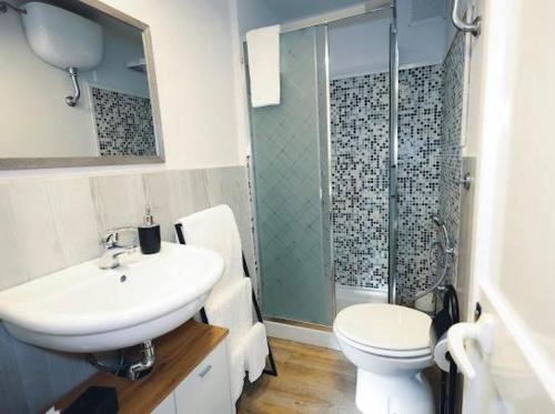 a bathroom with a sink and a toilet and a shower at Il laghetto 19 in Capodimonte