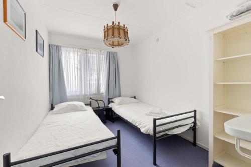 two beds in a room with a chandelier at Hello Zeeland - Vakantiehuis Weststraat 13A in Domburg