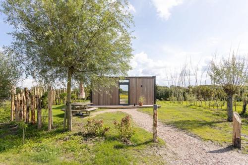 a small wooden cabin in a field with trees at ÖÖD Sunrise at Buitenplaats Zeeuwse Liefde in Westkapelle