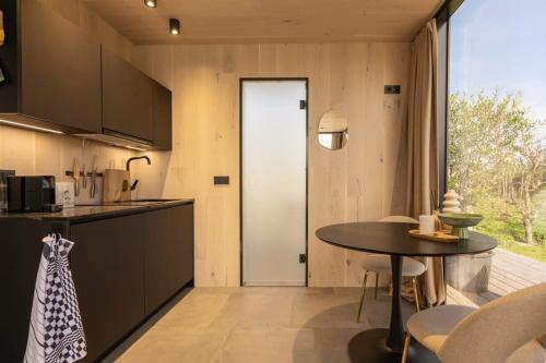 a kitchen and dining room with a table and chairs at ÖÖD Sunrise at Buitenplaats Zeeuwse Liefde in Westkapelle
