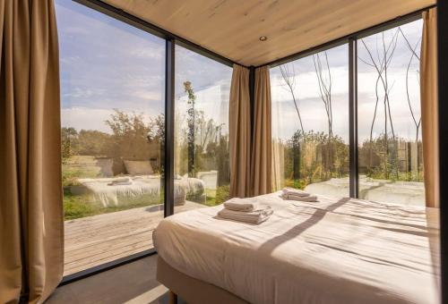 a bedroom with a large glass window and a bed at ÖÖD Sunrise at Buitenplaats Zeeuwse Liefde in Westkapelle