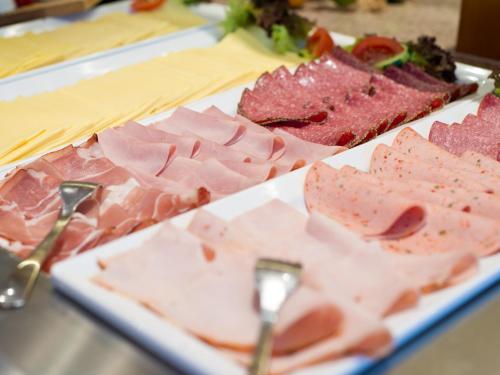 a plate of food with meat on a table at ACHAT Hotel Bochum Dortmund in Bochum