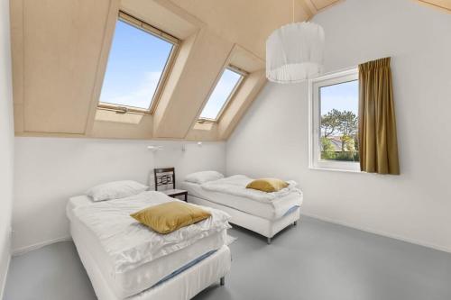 een slaapkamer met 2 bedden en 2 ramen bij NEW Hello Zeeland - Vakantiehuis Jhr De Casembrootplein 19 in Domburg