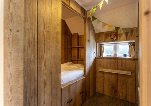 een kleine kamer met een bed en een raam bij De Kleine Schuur at Buitenplaats Zeeuwse Liefde in Westkapelle