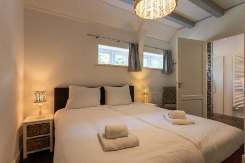 1 dormitorio con 1 cama blanca grande y 2 almohadas en De Grote Schuur at Buitenplaats Zeeuwse Liefde, en Westkapelle