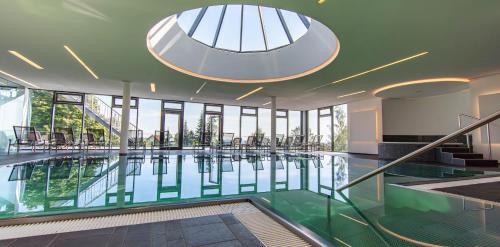 una piscina in un edificio con pavimento in vetro di Wellnesshotel Hohenrodt a Lossburg