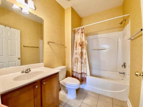 uma casa de banho com um lavatório, um WC e um chuveiro em Lakefront Condo w Huge Waterfront Pool Hot Tub em North Myrtle Beach