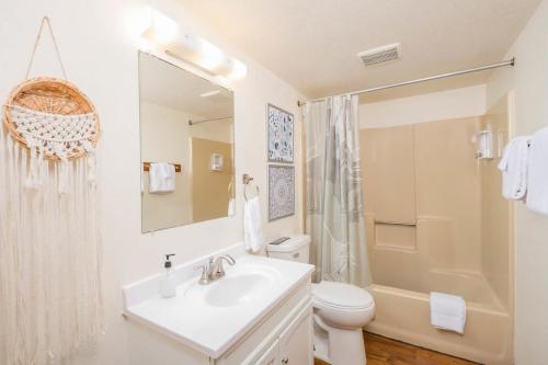 ein Badezimmer mit einem Waschbecken, einem WC und einem Spiegel in der Unterkunft Kaukauna Flats 9 in Kaukauna