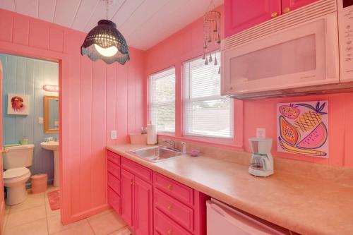 cocina rosa con lavabo y aseo en Inn the Pink One-in-a-Million Vacation Home en Myrtle Beach