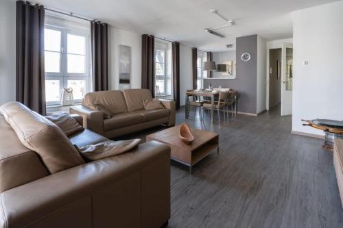 a living room with a couch and a table at Hello Zeeland - Duinhof V 1-7 in Cadzand