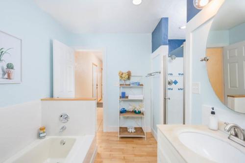 a white bathroom with a tub and a sink at Relaxing Downtown 2BR Abode in Appleton