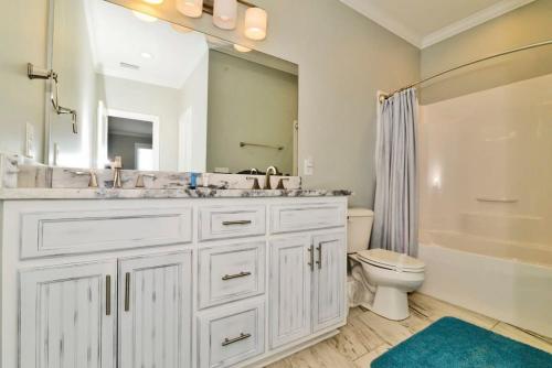 Baño blanco con lavabo y aseo en Anchor Down Luxury Ocean View Beach House w Pool, en Myrtle Beach