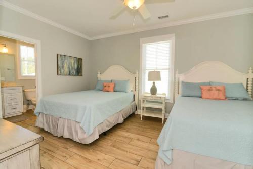 1 dormitorio con 2 camas con almohadas azules y naranjas en Anchor Down Luxury Ocean View Beach House w Pool, en Myrtle Beach