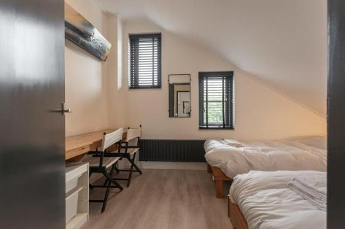 um quarto com 2 camas, uma secretária e janelas em Hello Zeeland - Spaanse Galeien 35 em Retranchement