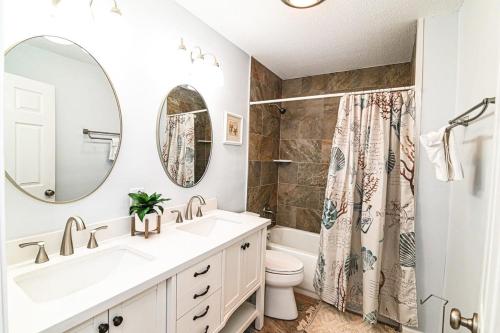 een badkamer met een wastafel, een toilet en een spiegel bij Island Breeze Pet Friendly Bungalow w Pool in Myrtle Beach