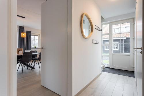 a hallway with a sliding door leading to a dining room at Hello Zeeland - vakantiewoning Knuitershoek 102 in Kloosterzande