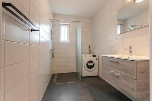 y baño con lavadora y lavamanos. en Hello Zeeland - vakantiewoning Knuitershoek 102 