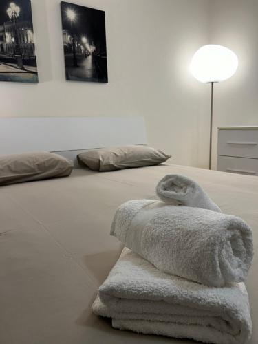 a bed with two towels on it with a lamp at Appartamento Blue View in Peschiera del Garda