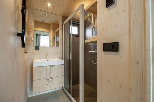 een badkamer met een douche en een wastafel bij Hello Zeeland - Tiny House Zeeuwse Liefde 6 in Westkapelle