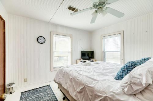 ein Schlafzimmer mit einem Bett und einer Uhr an der Wand in der Unterkunft Beechwood Bungalow - Where Comfortable Coastal and Calm Meet Waves Water and WOW in Freeport