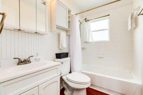a white bathroom with a toilet and a sink at Beechwood Bungalow - Where Comfortable Coastal and Calm Meet Waves Water and WOW in Freeport