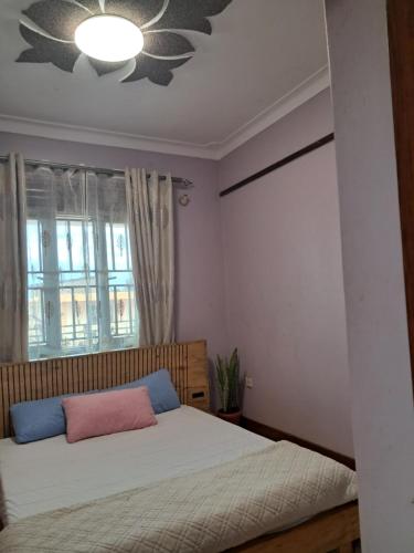 1 dormitorio con cama y ventana en ZET HOLDINGS, en Jinja