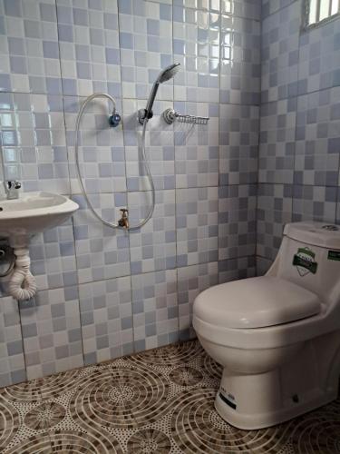 y baño con ducha, aseo y lavamanos. en ZET HOLDINGS, en Jinja