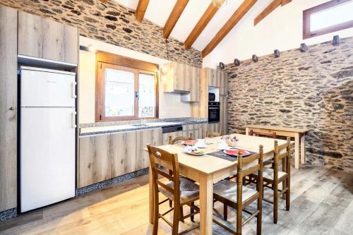 a kitchen with a wooden table and a white refrigerator at One bedroom apartement with enclosed garden and wifi at Mourisca 