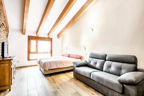 een woonkamer met een bank en een bed bij One bedroom apartement with enclosed garden and wifi at Mourisca 