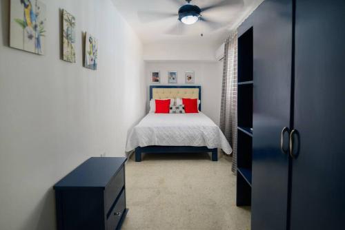 sypialnia z łóżkiem z czerwonymi poduszkami w obiekcie Casa Jobo - Mountain & Sea Panoramic view- 3Bedrooms w mieście Puerto Plata
