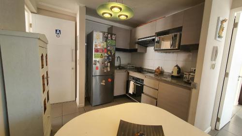 uma cozinha com uma mesa e um frigorífico em Edificio One em Iquique