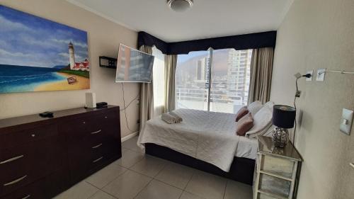 a bedroom with a bed and a large window at Edificio One in Iquique