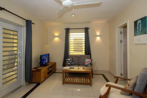 een woonkamer met een bank en een tafel bij Caracara M4 Relax & Dive Resort Bonaire Village in Kralendijk