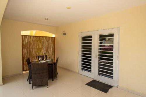 une salle à manger avec une table et une grande fenêtre dans l'établissement Caracara J4 Relax & Dive Resort Bonaire Village, à Kralendijk