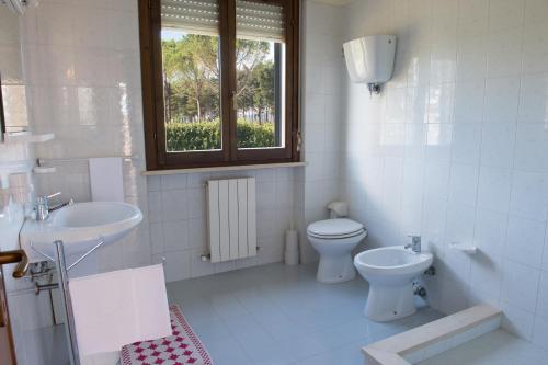 a white bathroom with a toilet and a sink at Appartamenti Tomassini in Spello