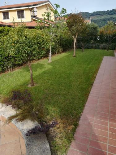 a yard with a lawn with trees and a house at VILLA MATI' in Pizzo