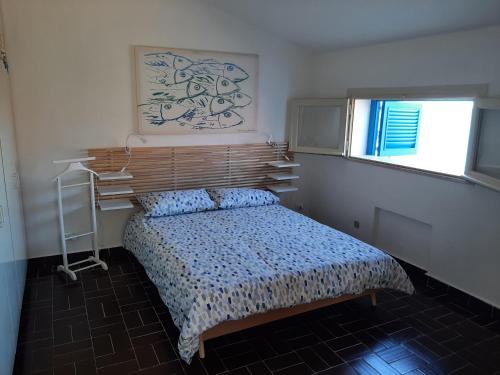 a bedroom with a bed with a wooden headboard at Appartamento In Villa Al Mare - Baia di Arcile in Brucoli