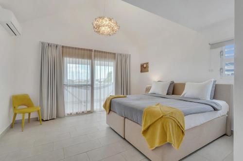 a bedroom with a bed with a yellow blanket on it at Casa Leeward with Pool on the Laguna Marina in Kralendijk