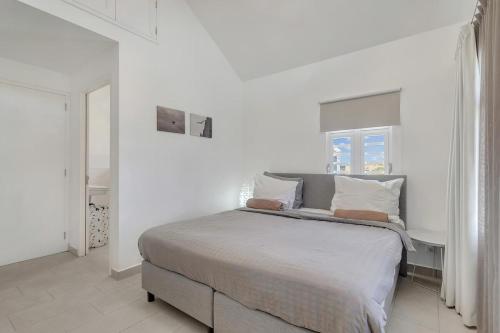 a white bedroom with a large bed with white walls at Casa Leeward with Pool on the Laguna Marina in Kralendijk